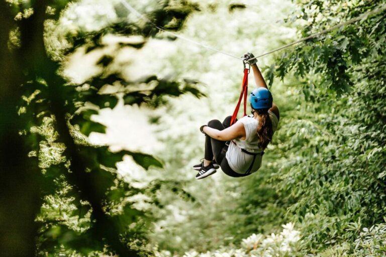Zipliner flying through the trees at Hawksnest