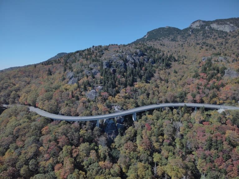 Aerial view of the Linn Cove Viaduct curving around Grandfather Mountain in fall colour
