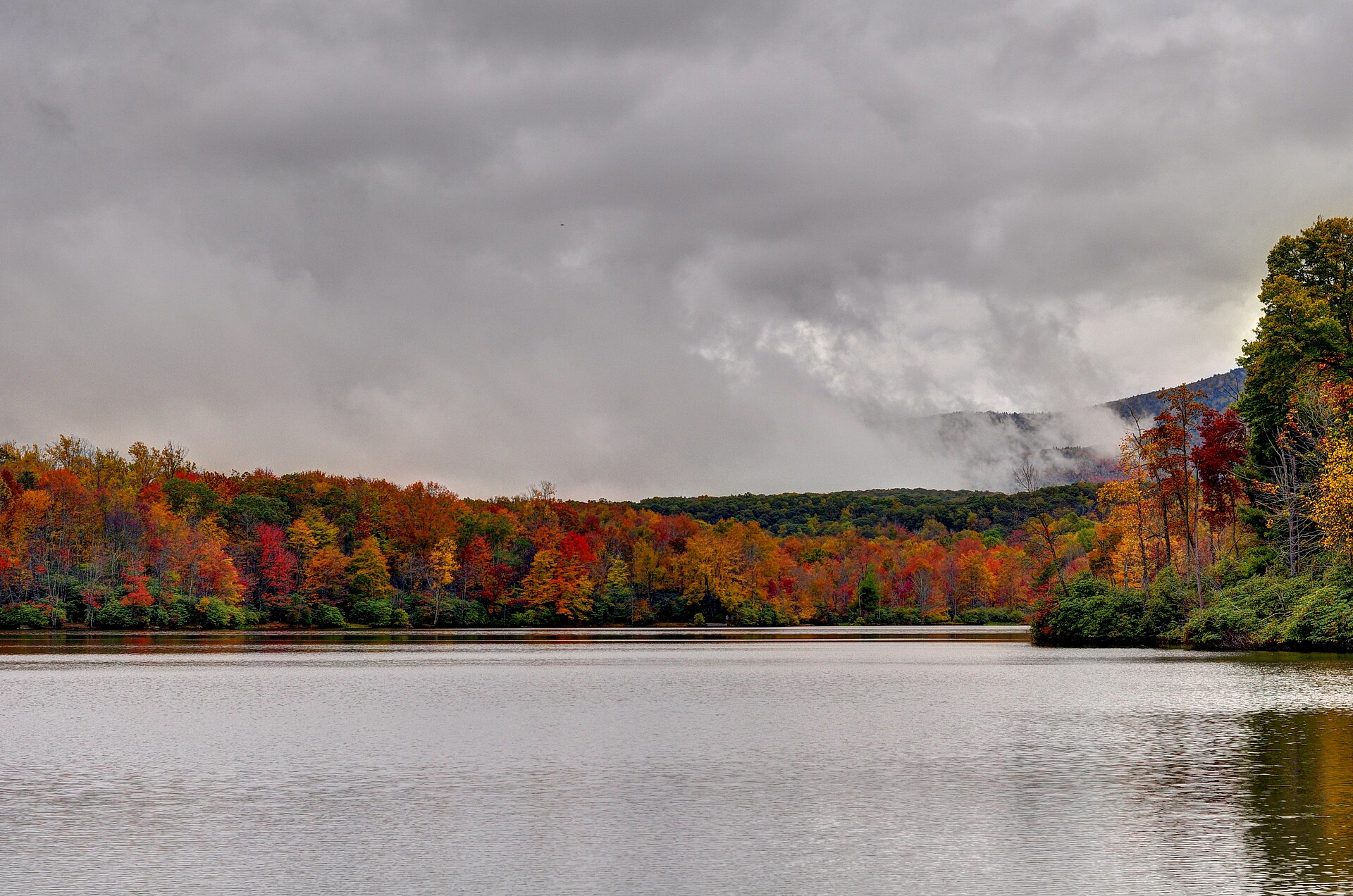 Autumn trees in red, orange and gold around Price Lake on the Blue Ridge Parkway