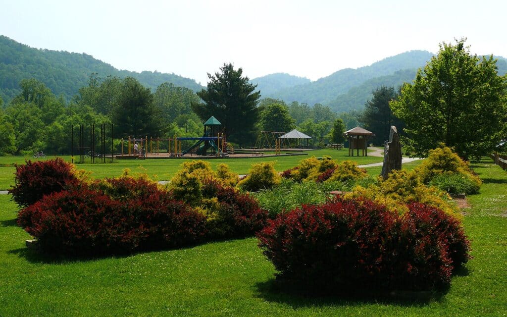 Lawns, gardens and gazebo at Valle Crucis Community Park with mountains behind