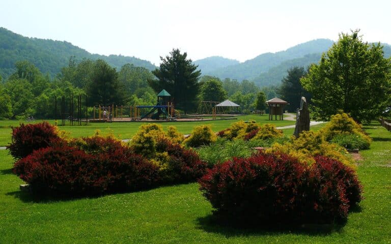 Lawns, gardens and gazebo at Valle Crucis Community Park with mountains behind