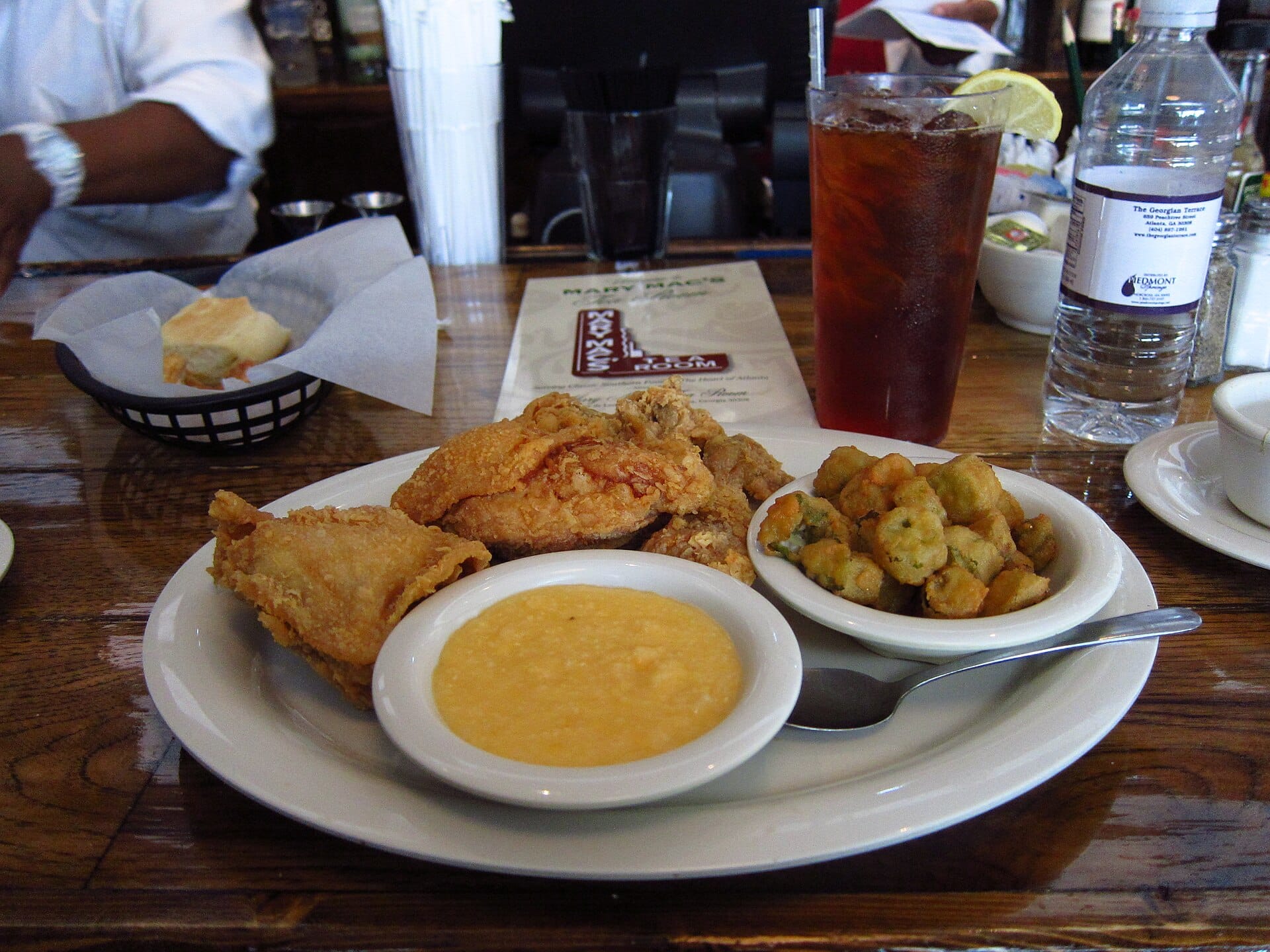 Plate of Southern fried chicken with grits, fried okra and sweet tea